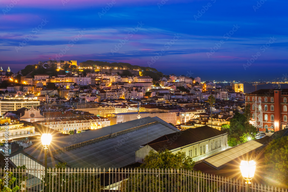 Obraz premium View of Lisbon famous view from Miradouro de Sao Pedro de Alcantara tourist viewpoint in the evening. Lisbon, Portugal. Camera pan
