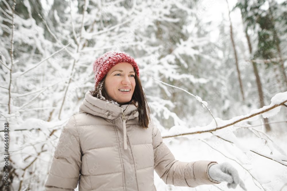 Young woman having fun on a walk in snow covered pine forest on chilly winter day. Female hiker exploring nature. Young woman having fun on a walk in snow covered pine forest on chilly winter day. Female hiker exploring nature.