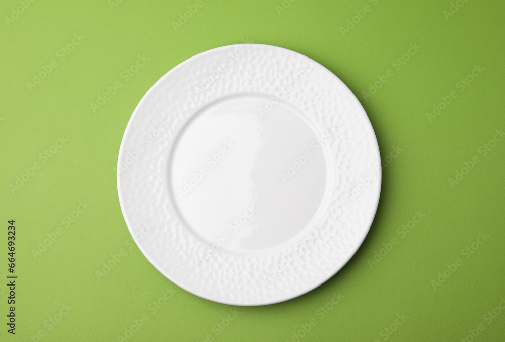 One clean plate on green background, top view One clean plate on green background, top view