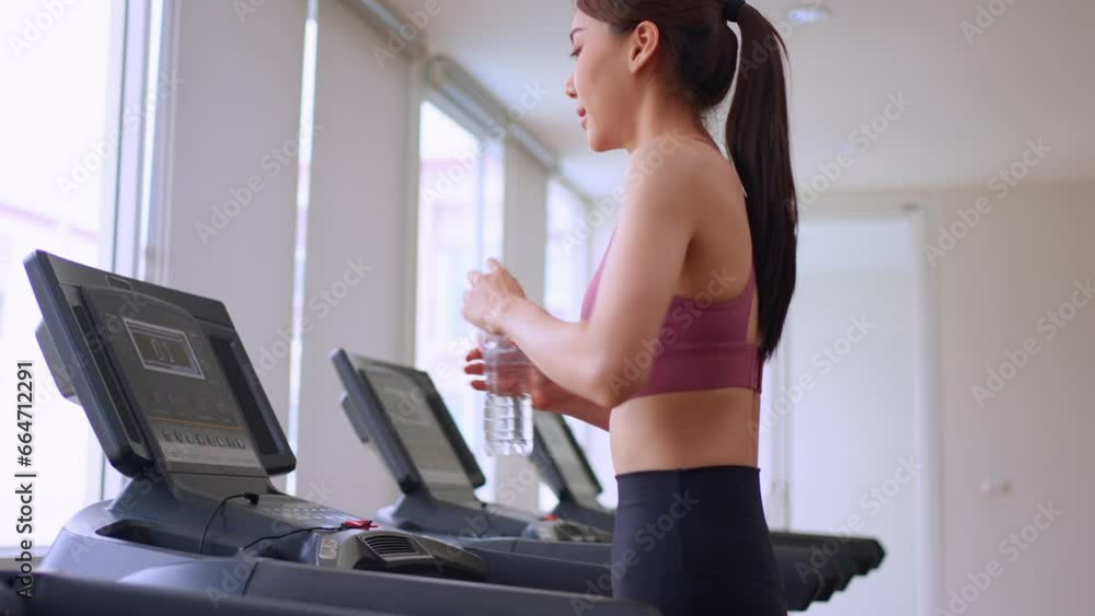 Asian young sportswoman exercise by running on treadmill in gym club. Asian young sportswoman exercise by running on treadmill in gym club.