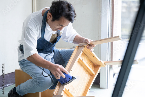 サンダーをかける男性 お家でDIY 趣味の時間 photo