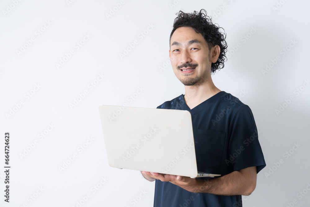 Smiling man looking at camera with laptop Image of bodyworker, nurse, doctor Smiling man looking at camera with laptop Image of bodyworker, nurse, doctor