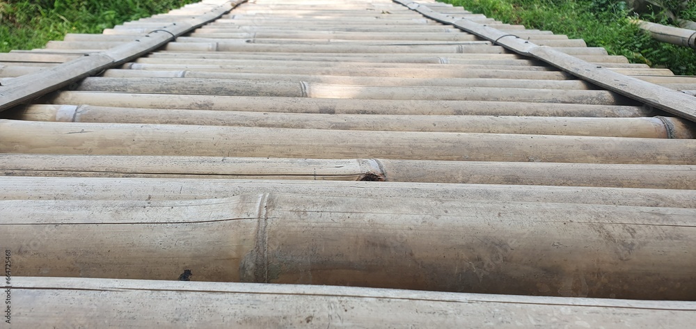 Fototapeta premium Wooden bamboo bridge pathway over the ponds