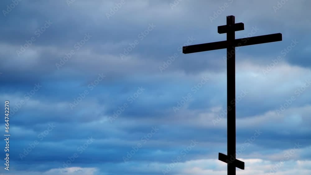 Holy Christian cross against the backdrop of moving clouds of the blue sky. The concept of the resurrection of Jesus Christ. Easter background. Holy Christian cross against the backdrop of moving clouds of the blue sky. The concept of the resurrection of Jesus Christ. Easter background.