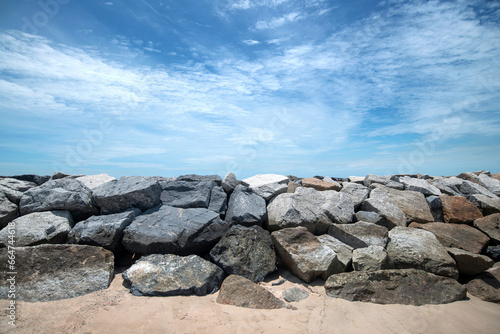Rocky breakwater with clouds and blue at Hat Saeng Chan beach in Rayong, THAILAND
