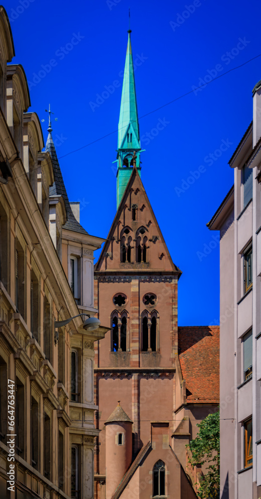 View onto the facade and tall spire of the Saint Pierre le Jeune Protestant church on Grande Ile, historic center of Strasbourg, Alsace, France