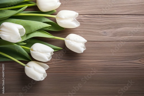 White tulips on wood table.