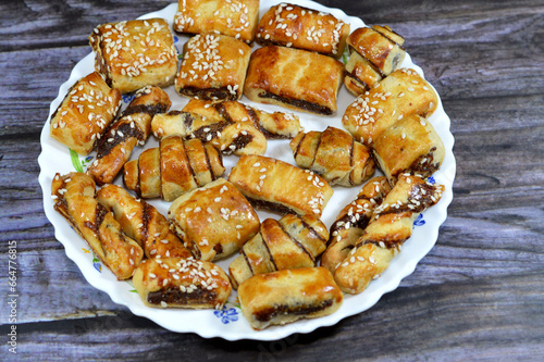 Pastry stuffed with dates and topped with sesame seeds or Ka'ab El Ghazal, Egyptian date or Agwa Ajwa filled cookies, famous middle eastern date filled pastries covered with sesame, selective focus photo