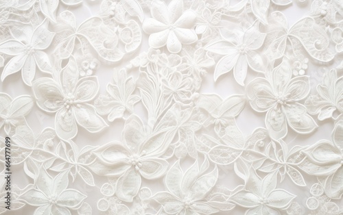 Closeup of textured fabric pattern with elegant vintage lace and floral hand embroidery on a white background. Decorative wedding design.