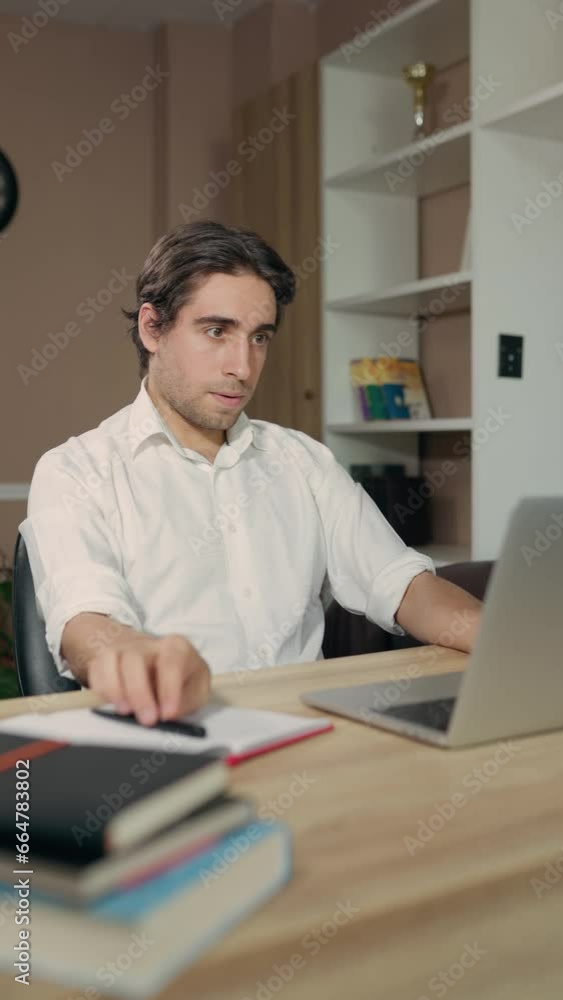 Freelancer Man Working Or Studying Remotely, Using laptop Sitting At Desktop In Home Office Freelancer Man Working Or Studying Remotely, Using laptop Sitting At Desktop In Home Office