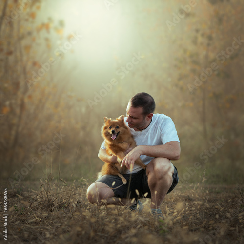 Forty year old man in the woods with his dog in a fairy tale atmosphere, bonding between man and dog. Friendship between animal and human