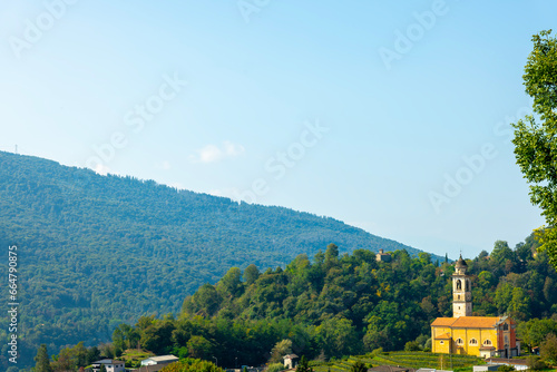 San Martino Provost Church on Mountain Range and Valley with Sky in a Sunny Summer Day in Malcantone, Sessa, Ticino, Switzerland photo