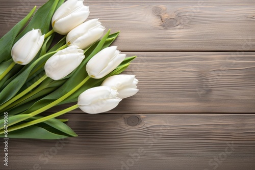 White tulips on wood table.