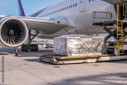 Air cargo logistic containers are loading to an airplane. Air transport shipment prepare for loading to modern freighter jet aircraft at the airport.