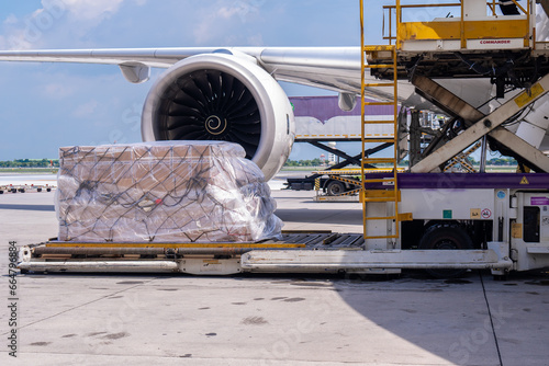 Air cargo logistic containers are loading to an airplane. Air transport shipment prepare for loading to modern freighter jet aircraft at the airport.