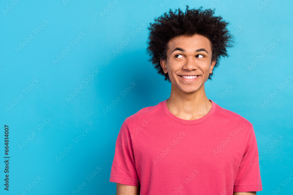 Photo of satisfied friendly man wear pink outfit watching empty space isolated on blue color background