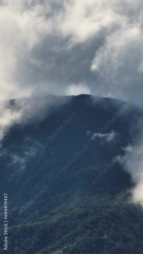 Blue sky and clouds covered over the mountain forest. Camiguin Island. Philippines. Vertical, stories. Blue sky and clouds covered over the mountain forest. Camiguin Island. Philippines. Vertical, stories.