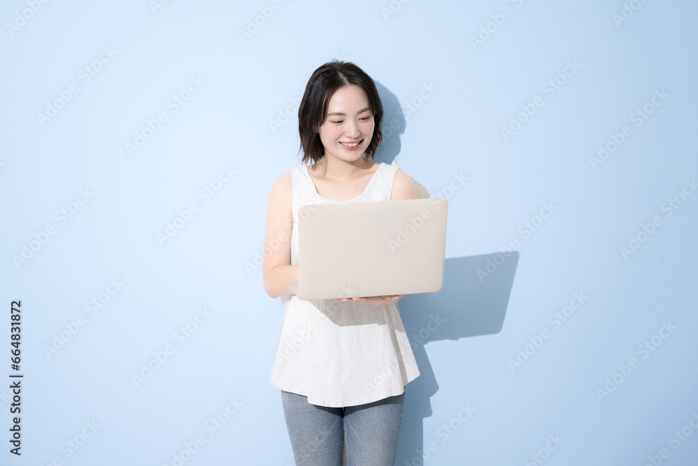 Cute woman using computer, fresh blue background Cute woman using computer, fresh blue background