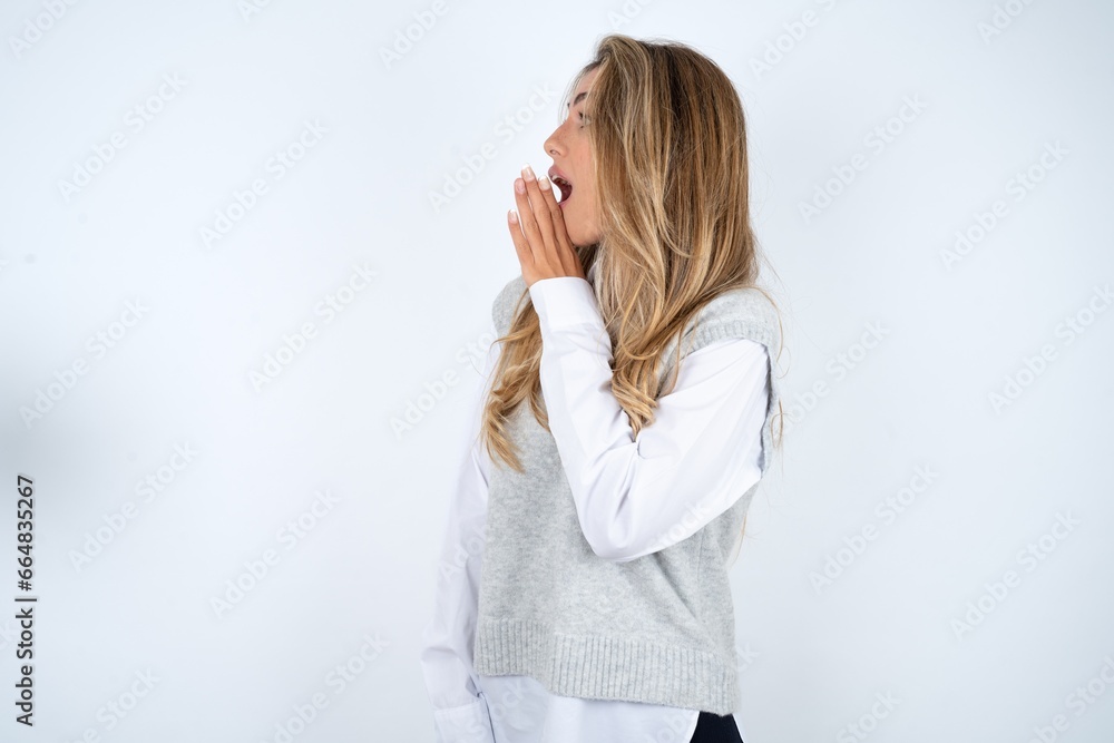 Half-faced close up portrait of astonished amazed Young business woman wearing formal clothing holding hand near mouth Half-faced close up portrait of astonished amazed Young business woman wearing formal clothing holding hand near mouth
