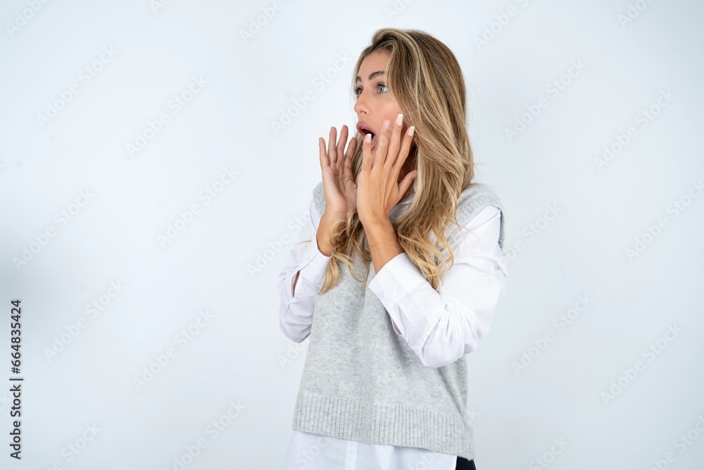 Young beautiful woman shouts loud, keeps eyes opened and hands tense. Young beautiful woman shouts loud, keeps eyes opened and hands tense.