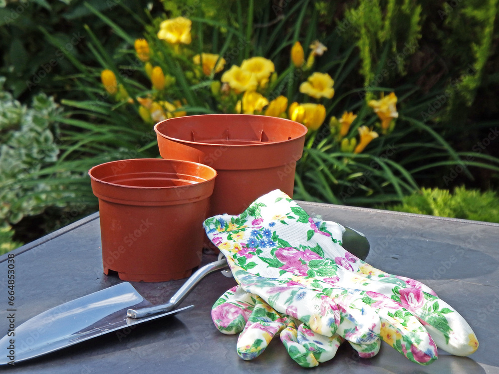 BHP w ogrodzie, rękawiczki ogrodowei, metalowa łopatka i doniczki na stole, Gardening tools, safe work in the garden, garden gloves, pots and metal shovel, gardening accessories on the table