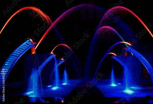 kolorowa fontanna oświetlona nocą, city fountain at night, arcs of water fountain, beautiful fountain. splash water. fountain in night 