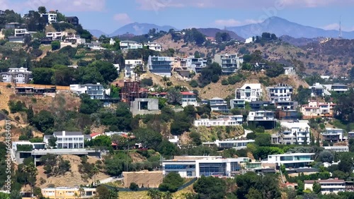 Aerial view cutting across large luxury neighborhood of homes in Hollywood hills daytime landscape
