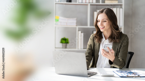 Happy young woman calling her friend talking and asking about something using laptop, middle aged business woman, female professional manager talking on the phone doing business on mobile phone