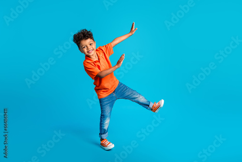 Full body size photo of dance cool little boy showing his arms dab carefree weekend positive mood disco isolated on blue color background