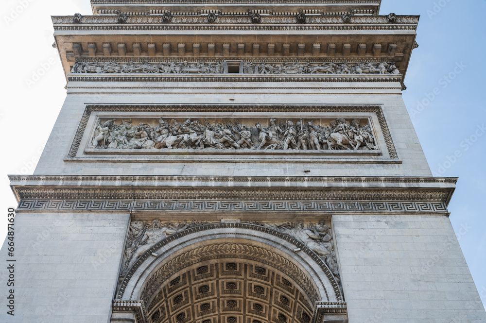 Arc de Triomphe, one of the most famous monuments in Paris, massive triumphal arch, located near Champs-Elysees in Paris. Close up, selective focus Arc de Triomphe, one of the most famous monuments in Paris, massive triumphal arch, located near Champs-Elysees in Paris. Close up, selective focus