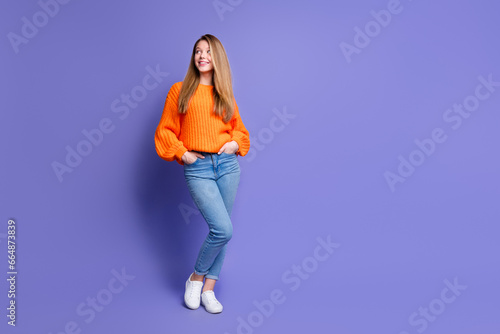 Full length portrait of adorable minded girl put hands pockets look empty space isolated on purple color background