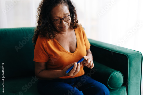 Managing type 1 diabetes: Woman injecting herself with insulin at home photo