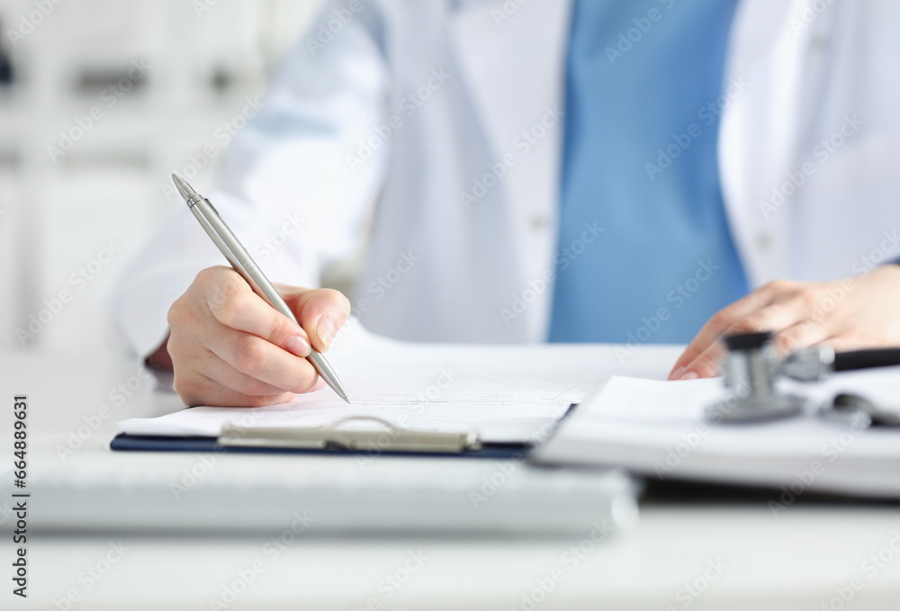 Female doctor hand hold silver pen filling patient history list at clipboard pad. Physical exam er disease prevention ward round visit check 911 prescribe remedy healthy lifestyle concept Female doctor hand hold silver pen filling patient history list at clipboard pad. Physical exam er disease prevention ward round visit check 911 prescribe remedy healthy lifestyle concept