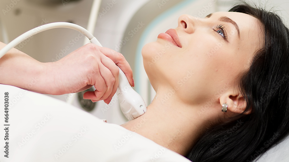 A doctor diagnoses a patient's thyroid gland using an ultrasound scanner. A woman holds an ultrasound probe along a patient's neck in a clinic. A doctor diagnoses a patient's thyroid gland using an ultrasound scanner. A woman holds an ultrasound probe along a patient's neck in a clinic.
