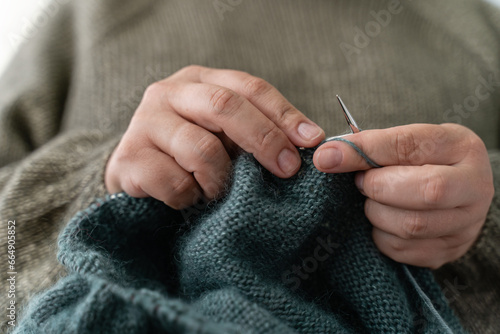 Close up of the woman s hand knitting the cozy sweater for a Christmas. Happiness and creative job