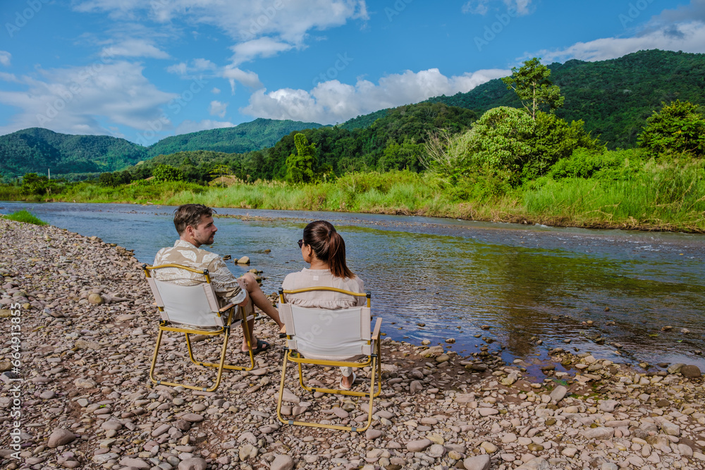 Fototapeta premium a couple of men and woman camping at the river in Nan Sapan Thailand, men and woman relaxing in the mountains of Northern Thailand