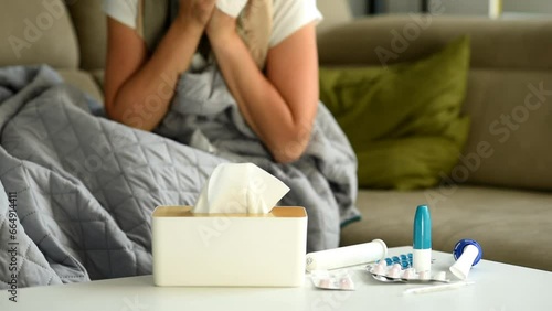 Illness, allergies and flu attacked the woman. The woman takes a paper napkin from the box and blows her nose.