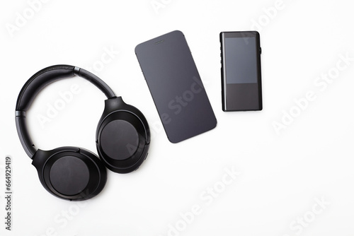 Noise-canceling headphones, a hi-fi player, and a smartphone on a white background