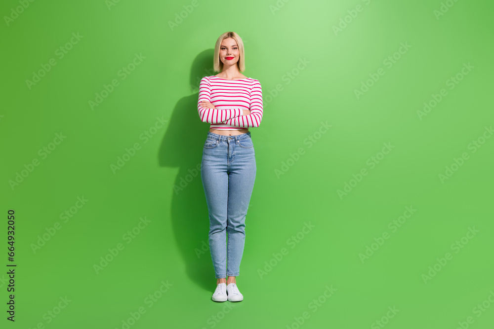 Full length photo of adorable satisfied woman with bob hairstyle wear striped shirt hold palms crossed isolated on green color background Full length photo of adorable satisfied woman with bob hairstyle wear striped shirt hold palms crossed isolated on green color background