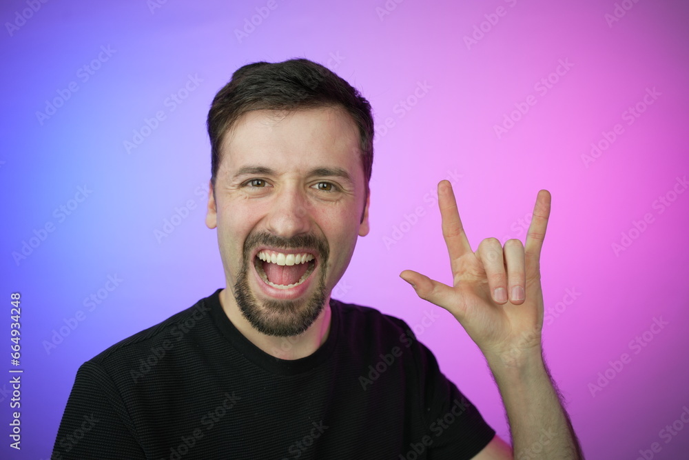 Young Man displaying the iconic rock gesture with his hand Young Man displaying the iconic rock gesture with his hand