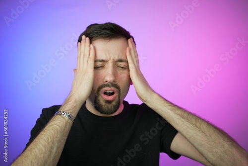 Man having headache, pink and blue background
