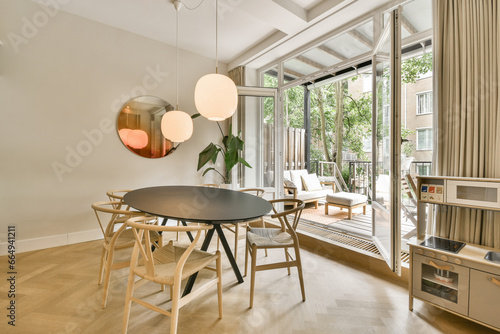 a dining table and chairs in a living room with sliding glass doors that open to the patio area  outside