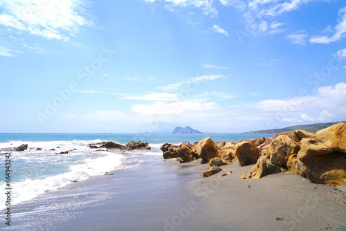 View from a rocky stretch of coast at La Alcaidesa across the Mediterranean to the Rock of Gibraltar, Playa de Torrecarbonera, Andalusia, Costa del Sol, Malaga, Spain