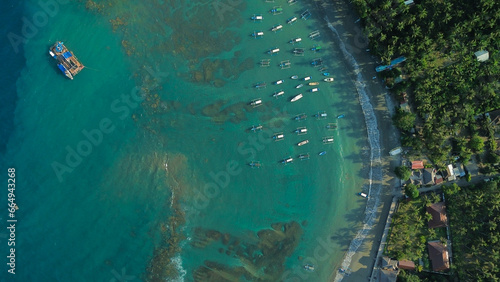 Aerial view of boats for diving trips parked off the shore of the tropical island of Bali. Colorful boats for diving trips near the beach  top-down view. Adventure and travel concept.