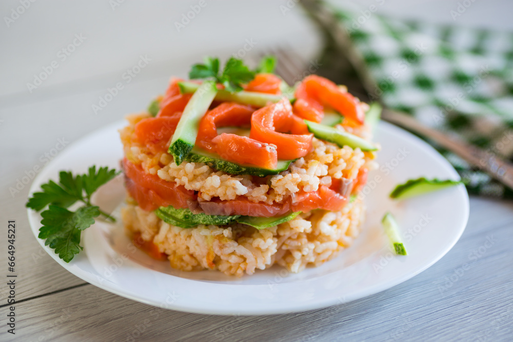 Boiled white rice with salted red fish, cucumbers and other vegetables with herbs in a plate. Boiled white rice with salted red fish, cucumbers and other vegetables with herbs in a plate.