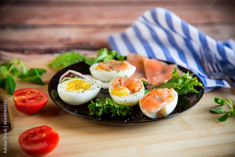 boiled eggs with salted red fish, herbs and seasonings in a plate . boiled eggs with salted red fish, herbs and seasonings in a plate .
