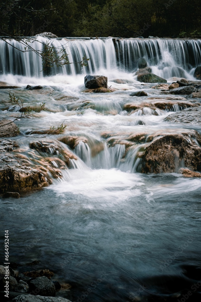 Fototapeta premium Vertical of a waterfall cascading down the rocks