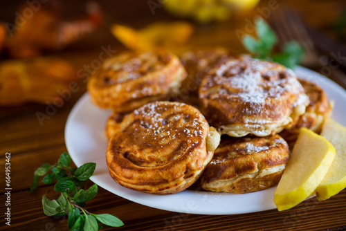 Cooked fried round pancakes with quince filling on a wooden table