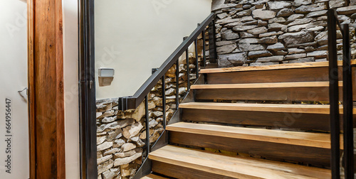 wooden staircase and stone cladding wall in rustic hallway cozy home interior design of mode photo
