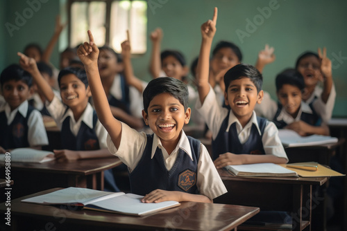 Indian school children hands up for answering to question in classroom